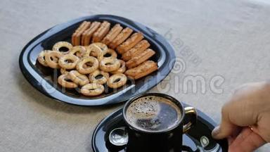 在桌子上放一杯咖啡。 桌子上有一个盘子里有自制的饼干。